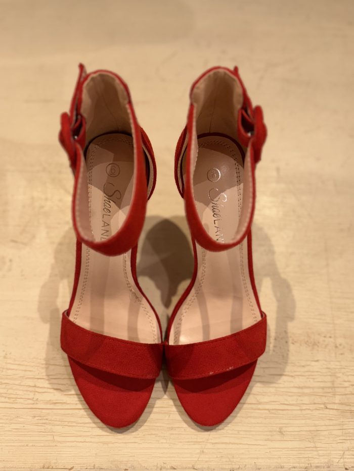 striking red suede sandals with a scalloped design and delicate ankle straps